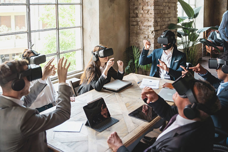 Des collègues avec un casque de réalité virtuelle autour d'une table.